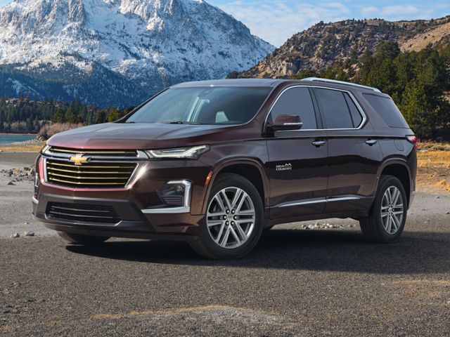 A burgundy 2023 Chevy Traverse in front of snow-capped mountains