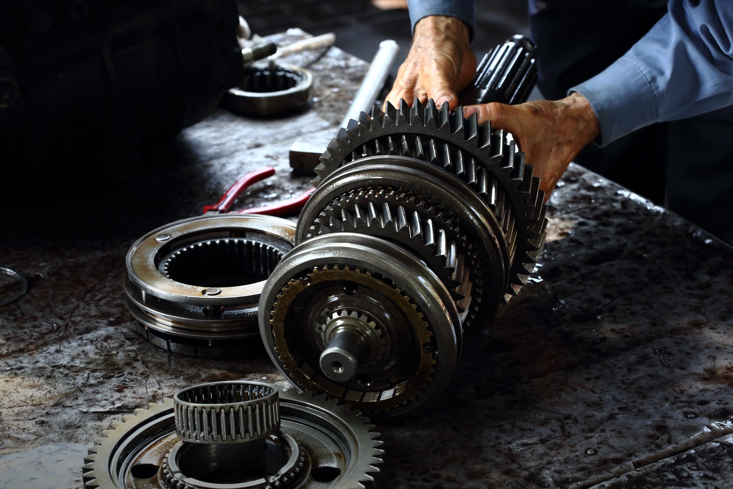 A photo of a technician repairing a transmission.